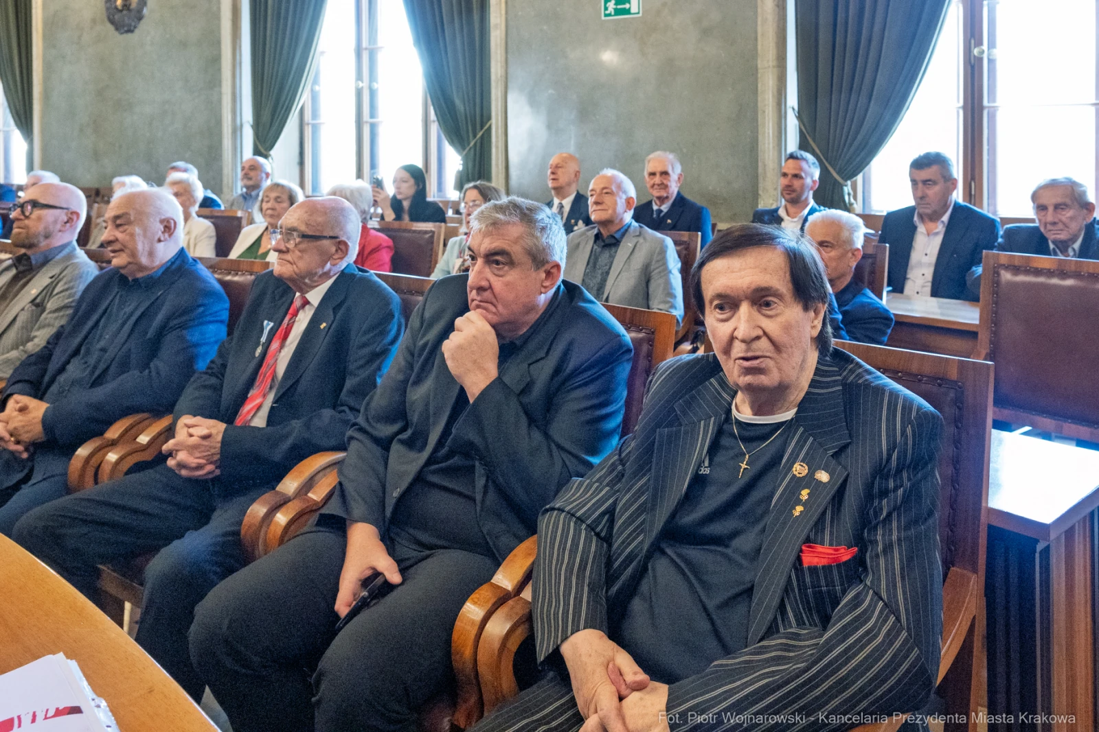 Grupa mężczyzn siedzących w sali, w formalnych strojach, podczas spotkania lub wydarzenia.  Autor: Piotr Wojnarowski