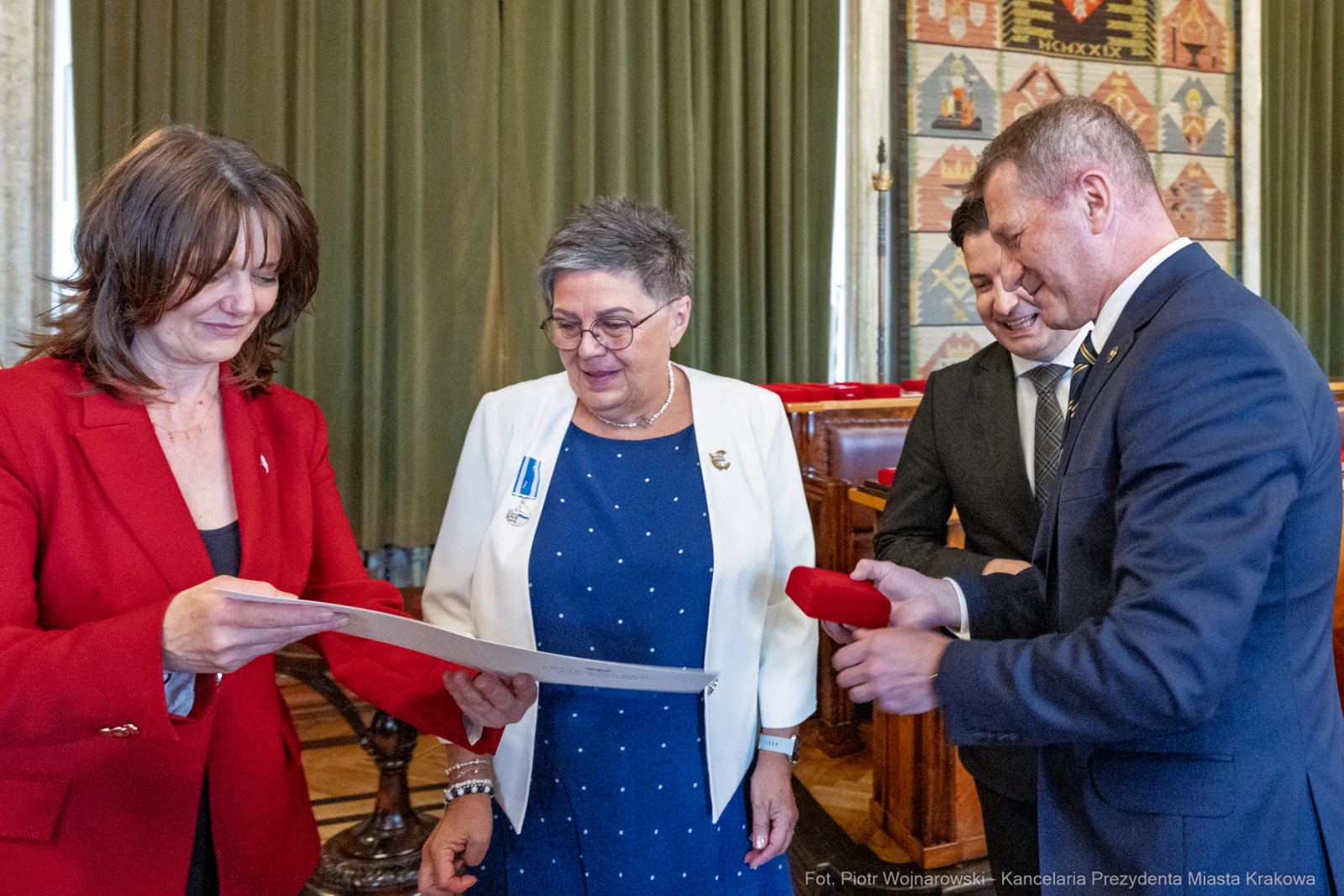 Wręczenie odznaczeń w sali obrad, uczestnicy w formalnych strojach.  Autor: Piotr Wojnarowski