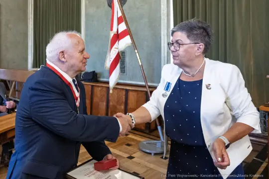 Uroczystość wręczenia odznaczeń, uścisk dłoni między dwiema osobami.