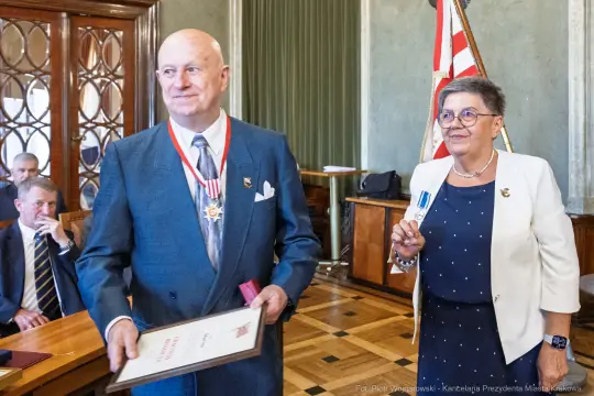 Uroczystość wręczenia odznaczeń, mężczyzna z medalem i dyplomem, kobieta z odznaką.