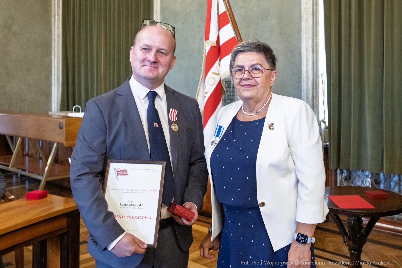 Mężczyzna z odznaczeniem i dyplomem oraz kobieta w białej marynarce z medalem.  Autor: Piotr Wojnarowski