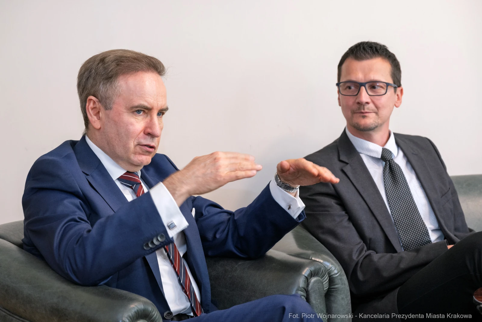 Dwóch mężczyzn w garniturach rozmawia w biurze. Jeden gestykuluje, drugi słucha.  Autor: Piotr Wojnarowski