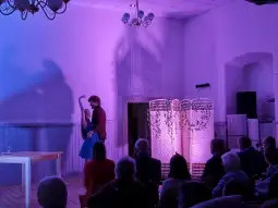 Taniec pary w kolorowym świetle na tle widowni.