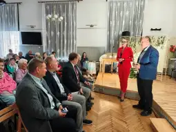 Spotkanie z prelekcją, uczestnicy siedzą na widowni, prowadzący rozmawia z gośćmi.