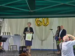 Uroczystość z okazji 60-lecia, przemawiająca osoba i goście na scenie.