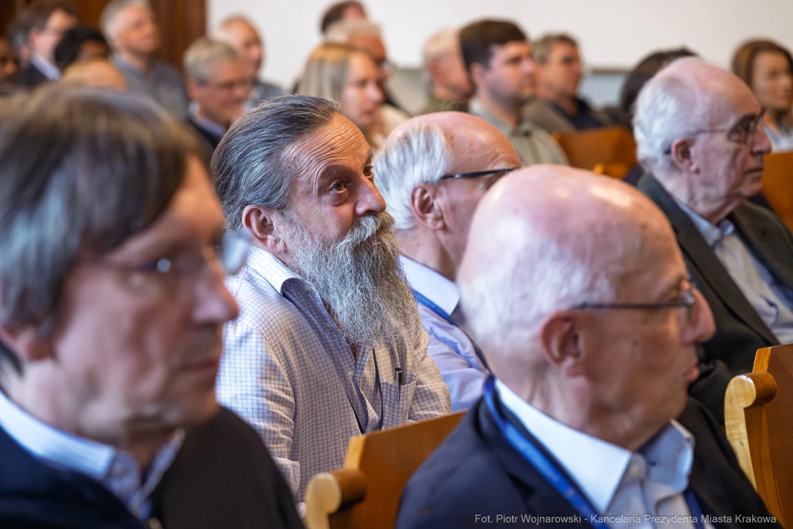Grupa mężczyzn w sali konferencyjnej, niektórzy z brodami, słuchających prelekcji.  Autor: Piotr Wojnarowski