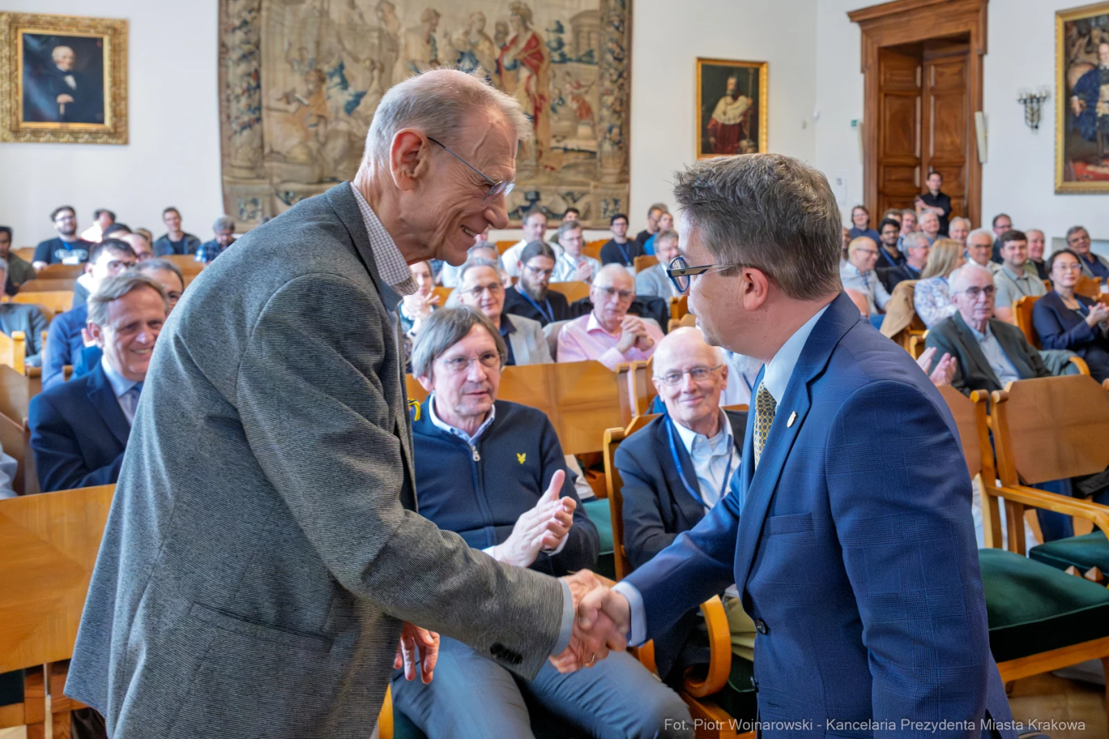 Spotkanie dwóch mężczyzn podczas wydarzenia w sali z publicznością.  Autor: Piotr Wojnarowski