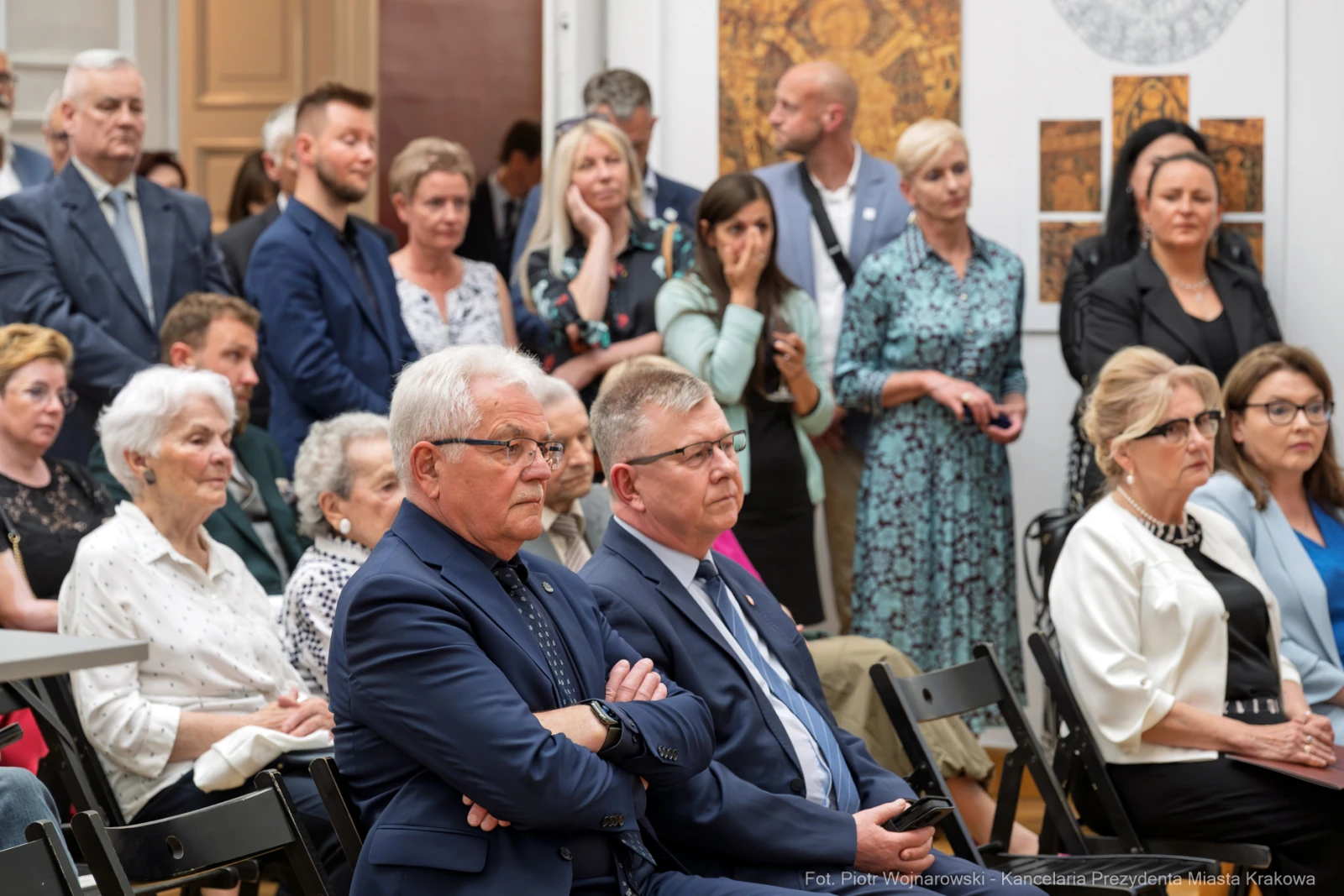 Grupa ludzi w eleganckich strojach, słuchających wystąpienia w sali.  Autor: Piotr Wojnarowski