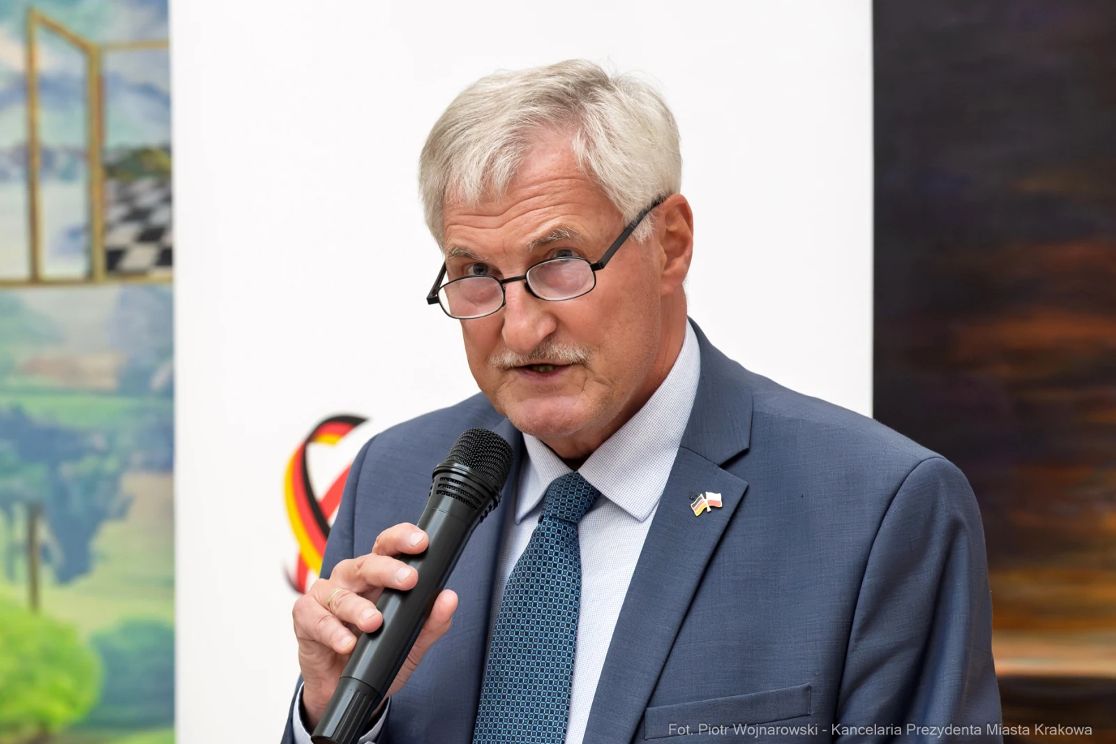 Mężczyzna w okularach trzyma mikrofon i przemawia.  Autor: Piotr Wojnarowski