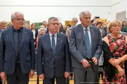 Grupa ludzi w eleganckich strojach podczas wydarzenia kulturalnego.