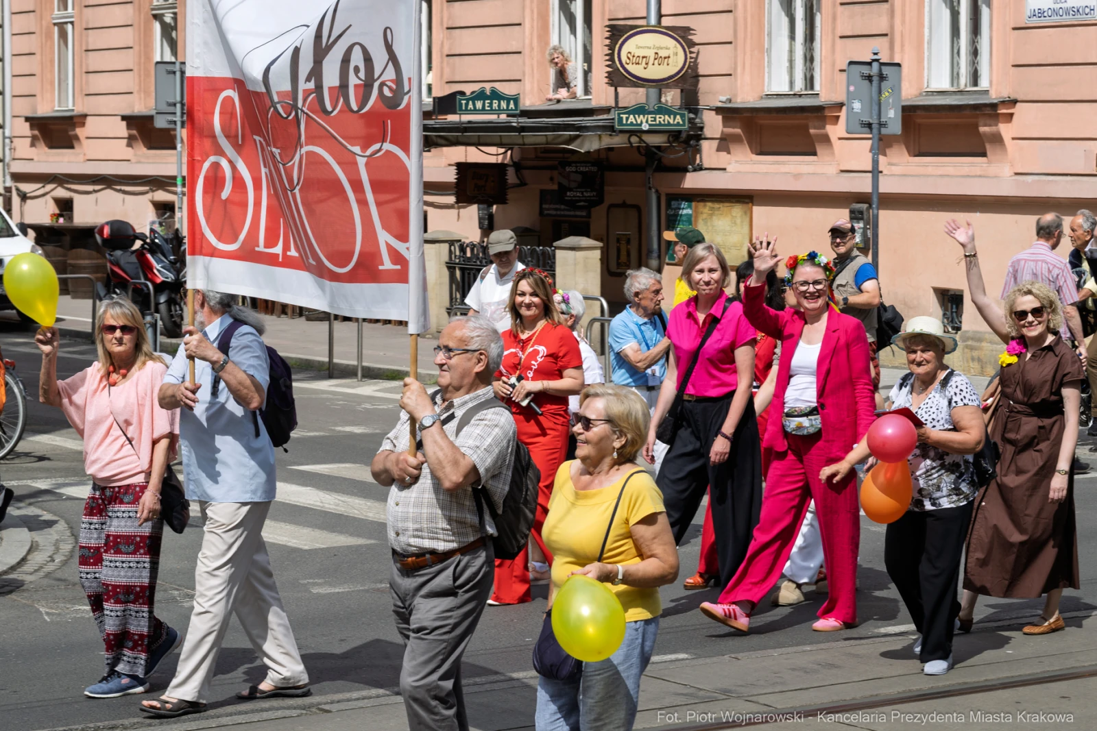 Parada z transparentem, uczestnicy niosą balony, radosna atmosfera.  Autor: Piotr Wojnarowski