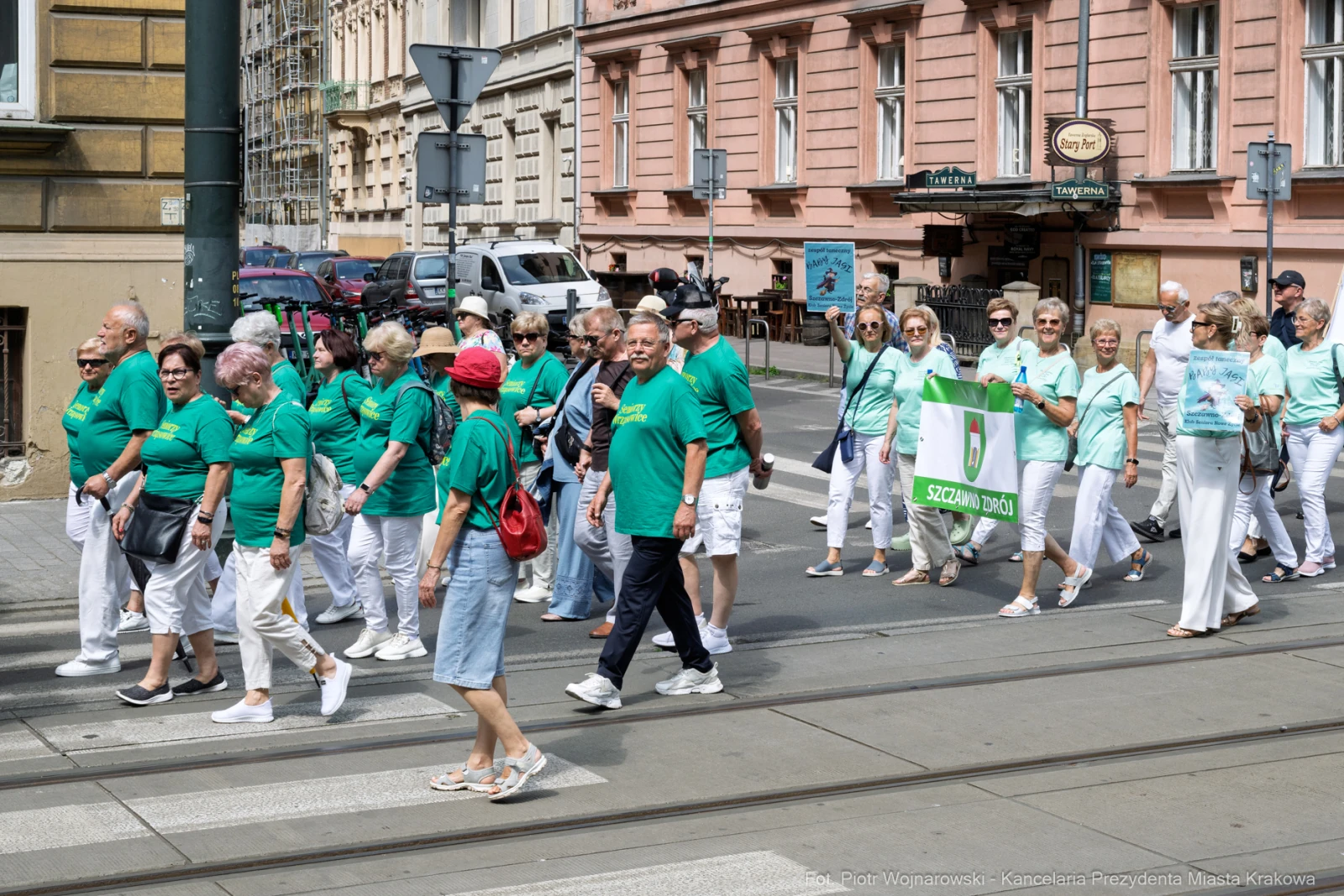 Grupa osób w zielonych koszulkach idzie ulicą, niosąc transparent z napisem Szczecin.  Autor: Piotr Wojnarowski