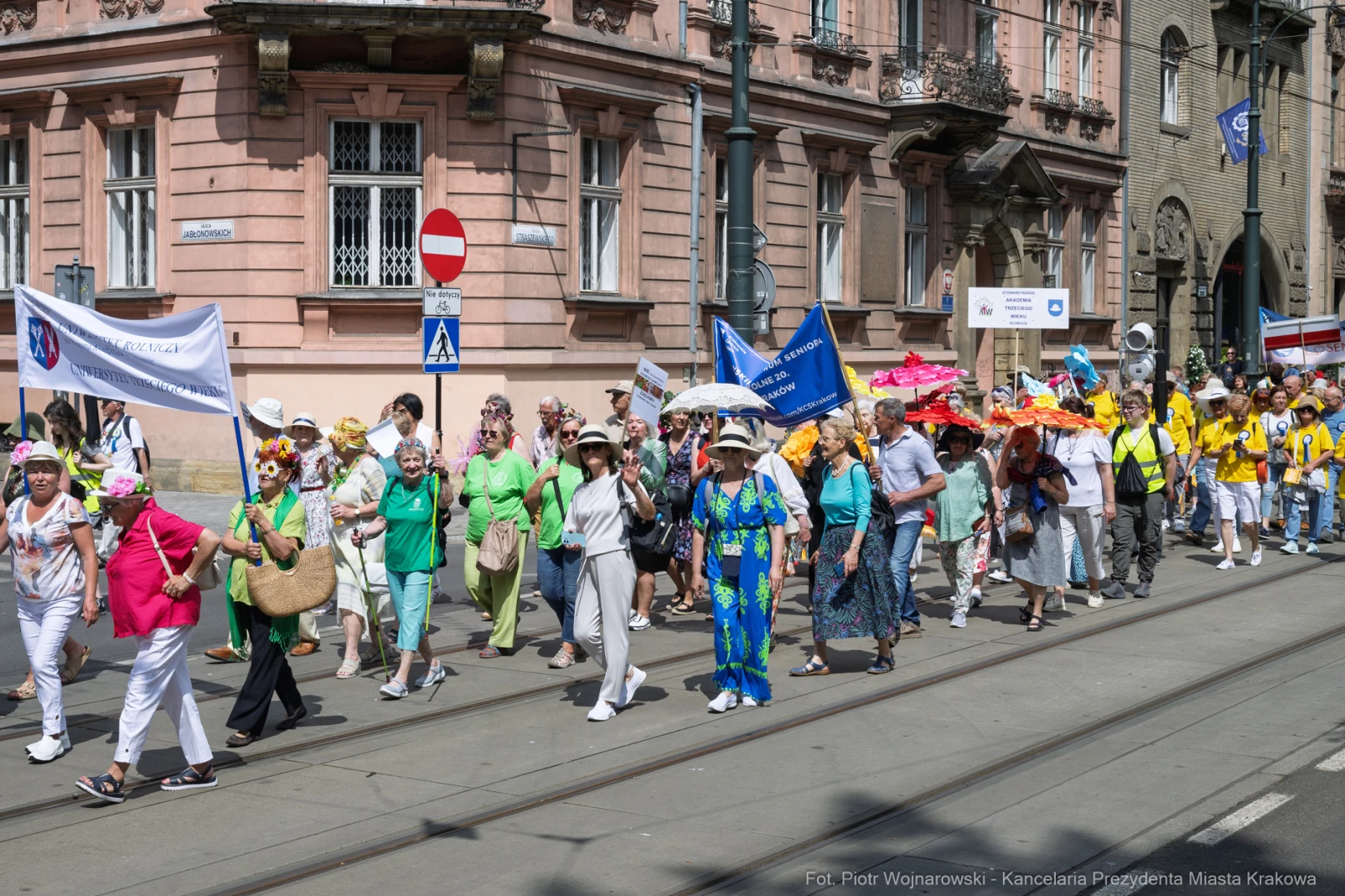 Tłum ludzi w kolorowych strojach i z parasolami, maszerujący ulicą.  Autor: Piotr Wojnarowski