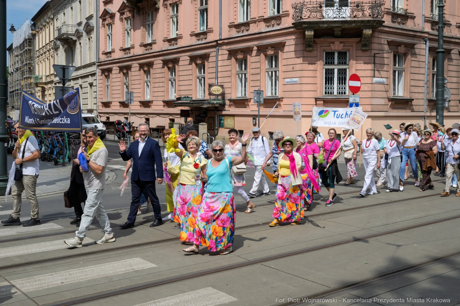 Tłum ludzi w kolorowych strojach maszeruje ulicą, trzymając transparenty.  Autor: Piotr Wojnarowski