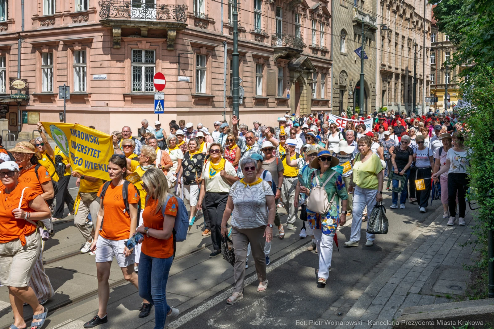 Tłum ludzi maszerujących ulicą, trzymających transparenty i flagi.  Autor: Piotr Wojnarowski