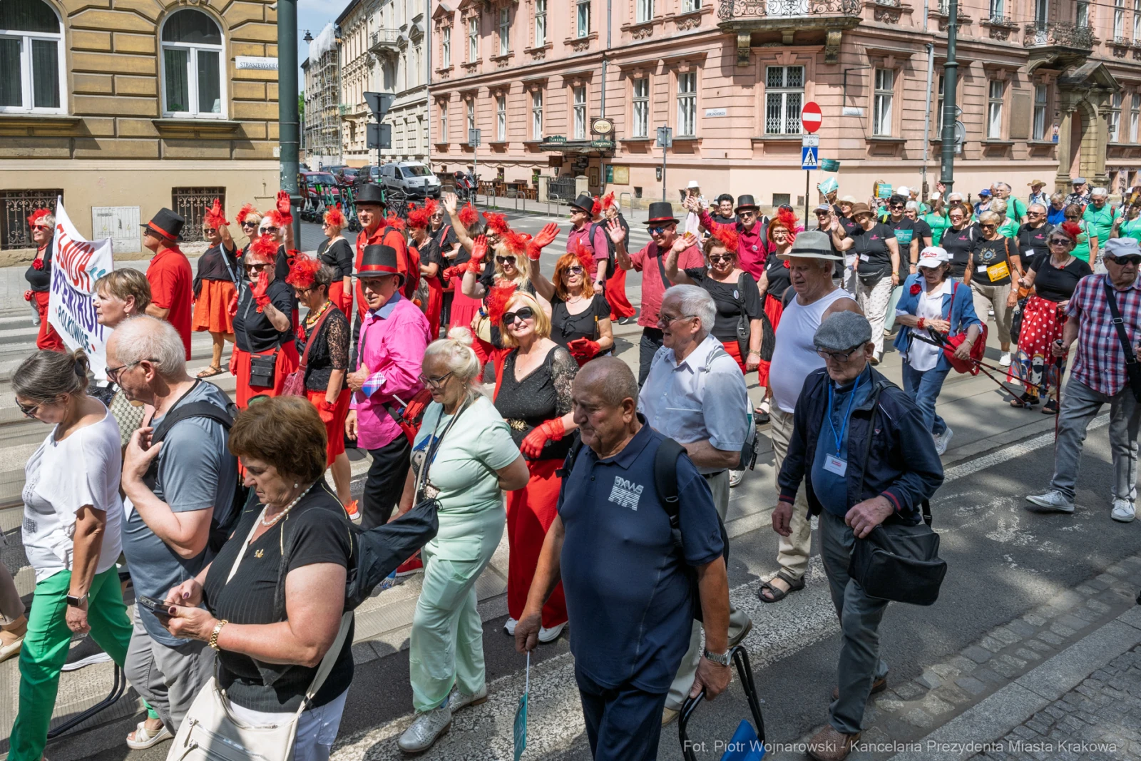 Tłum ludzi w kolorowych strojach maszeruje ulicą podczas wydarzenia kulturalnego.  Autor: Piotr Wojnarowski