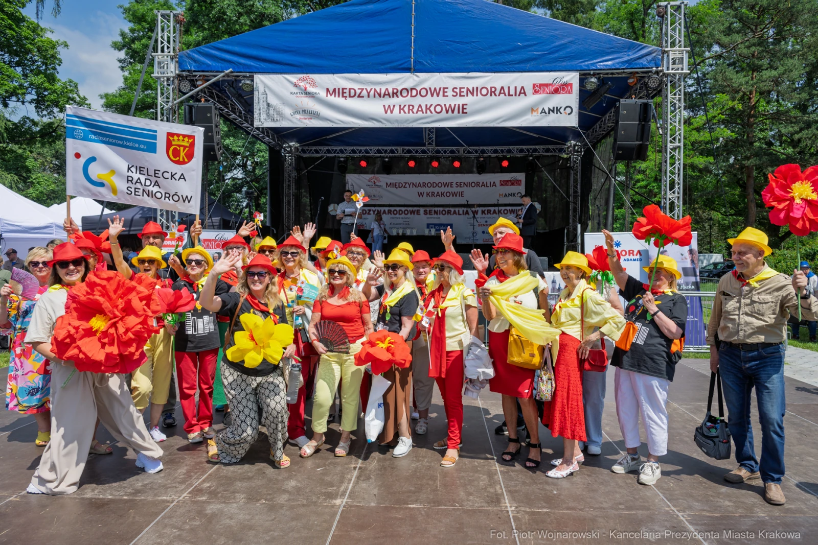 Grupa seniorów w kolorowych strojach z kwiatami na festiwalu w Krakowie.  Autor: Piotr Wojnarowski