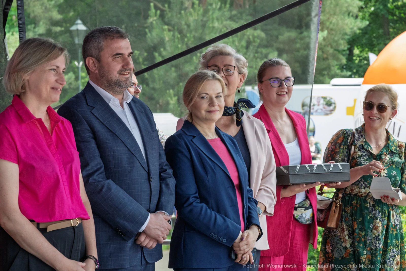 Grupa osób na wydarzeniu, uśmiechnięte, w eleganckich strojach, z różnymi akcesoriami.  Autor: Piotr Wojnarowski