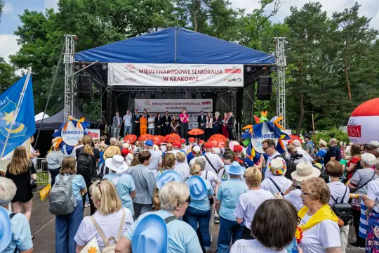 Tłum seniorów na wydarzeniu z wystąpieniami na scenie w Krakowie.