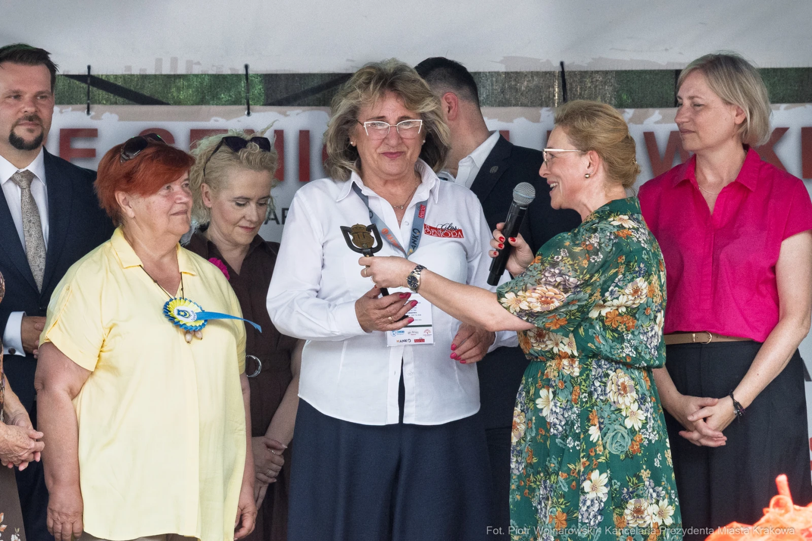 Wręczenie nagrody podczas uroczystości, uczestnicy w strojach formalnych.  Autor: Piotr Wojnarowski
