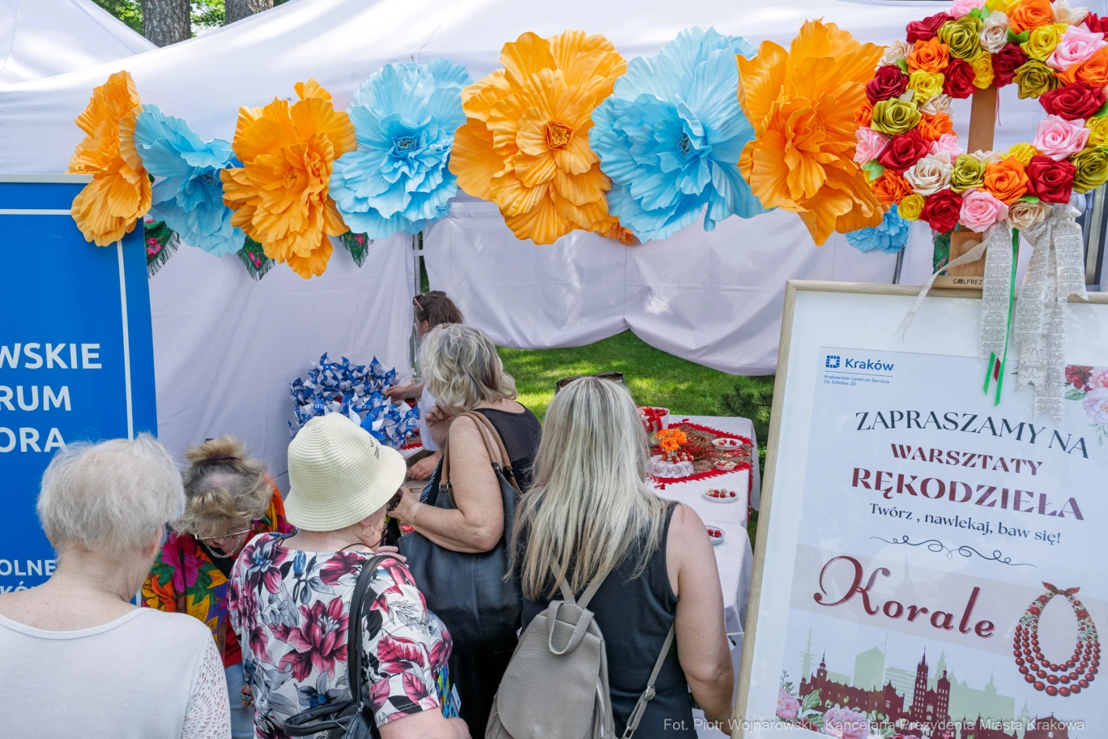 Warsztaty rękodzieła z koralami, kolorowe dekoracje i uczestnicy w tle.  Autor: Piotr Wojnarowski