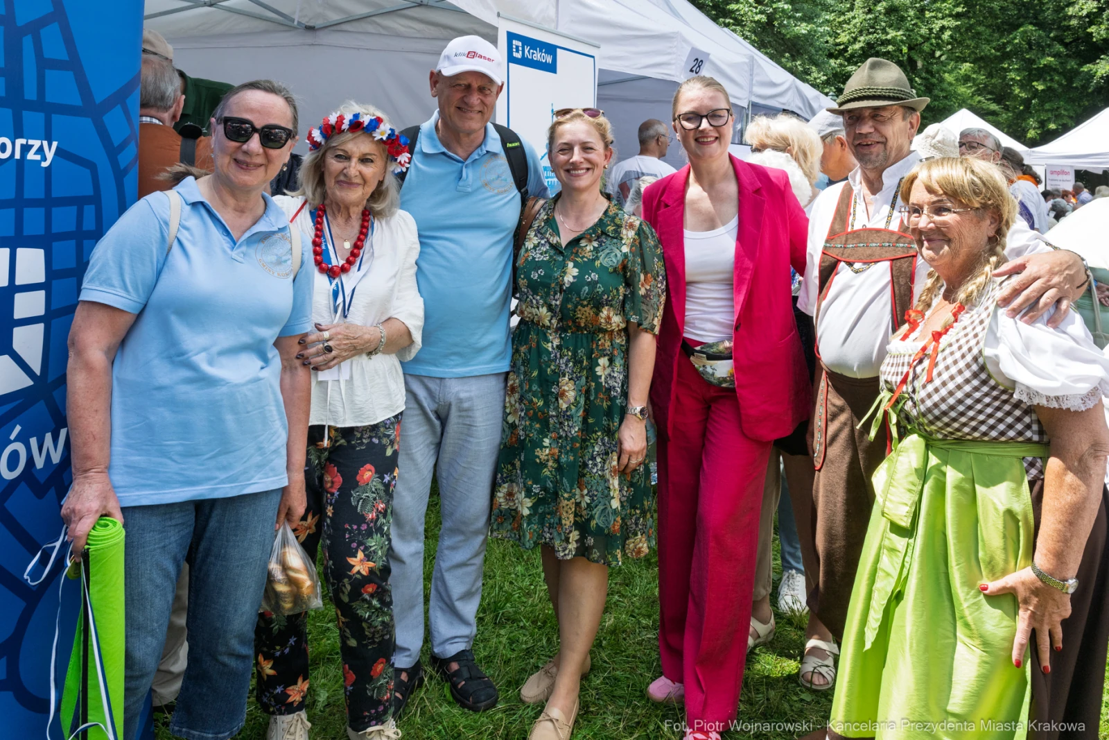 Grupa osób w kolorowych strojach, uśmiechniętych, na tle namiotów festiwalowych.  Autor: Piotr Wojnarowski