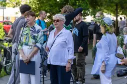 Kobiety przemawiają na wydarzeniu publicznym, w tle uczestnicy i zieleń.