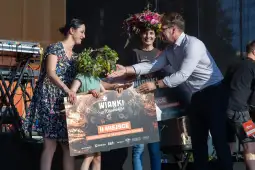 Kobiety z wiankami na głowach odbierają nagrody na festiwalu.