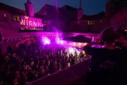 Impreza w zamku z tańczącymi ludźmi i kolorowymi światłami.