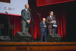 Wręczenie nagrody podczas uroczystości z przemówieniami na scenie.