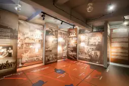 Wystawa z informacjami i zdjęciami historycznymi na ścianach oraz mapą na podłodze.