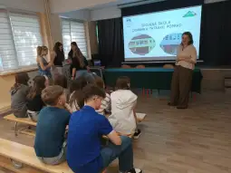 Prezentacja o szkole Dominika i Tadeusza w Popradzie, uczniowie słuchają nauczycielki.