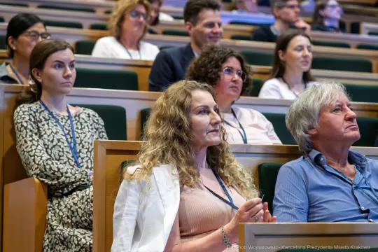 Grupa osób siedzących na widowni podczas konferencji.