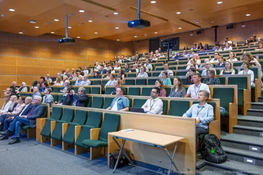 Sala wykładowa z dużą grupą uczestników konferencji.