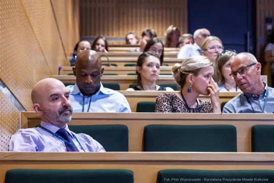 Grupa ludzi siedzących na widowni podczas konferencji.
