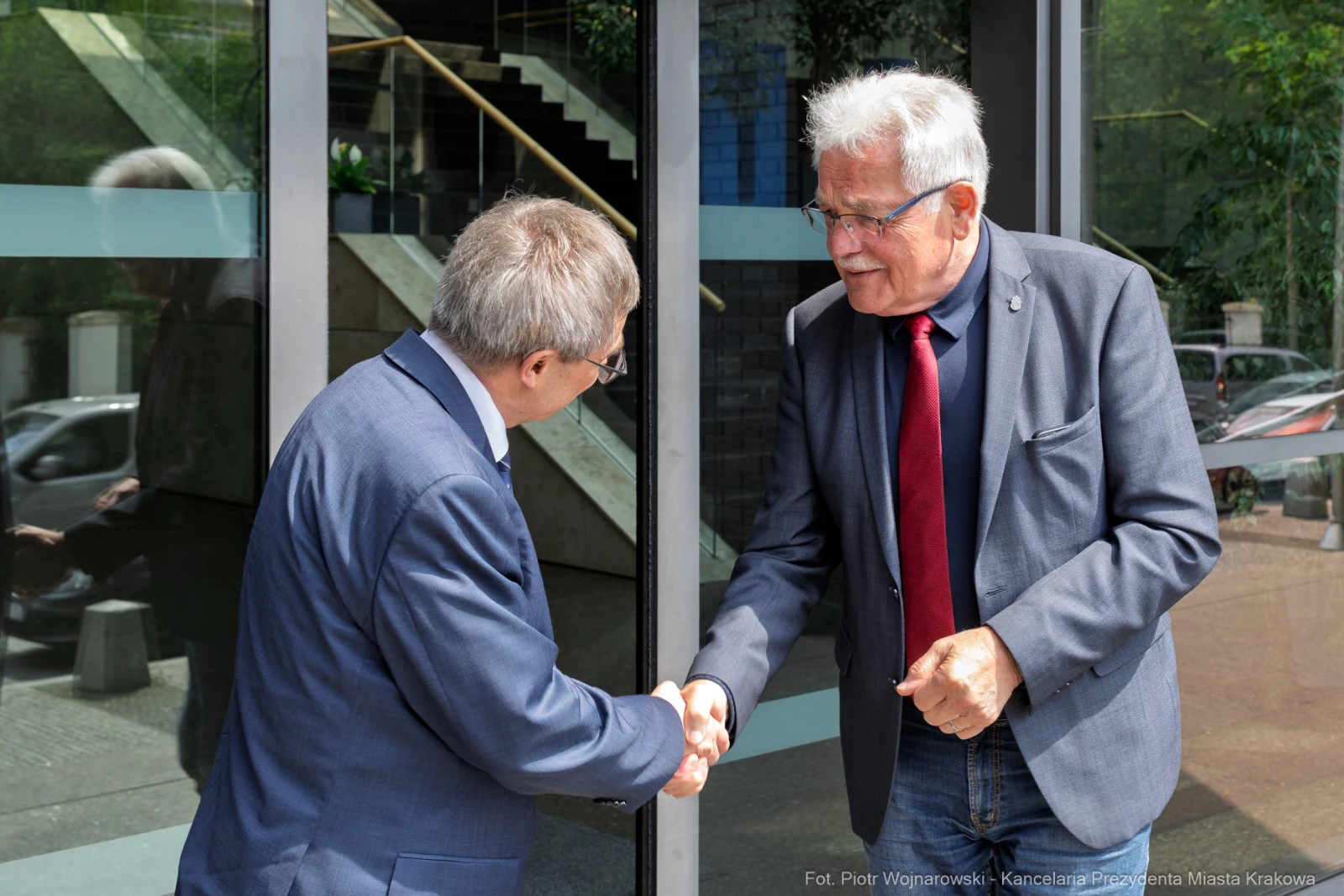 Dwaj mężczyźni podają sobie ręce przy drzwiach.  Autor: Piotr Wojnarowski