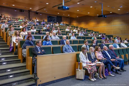 Grupa ludzi siedzących na widowni podczas konferencji w sali wykładowej.