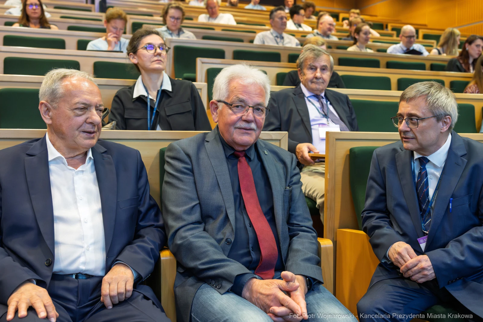 Trzech mężczyzn w garniturach siedzi na widowni w sali konferencyjnej.  Autor: Piotr Wojnarowski
