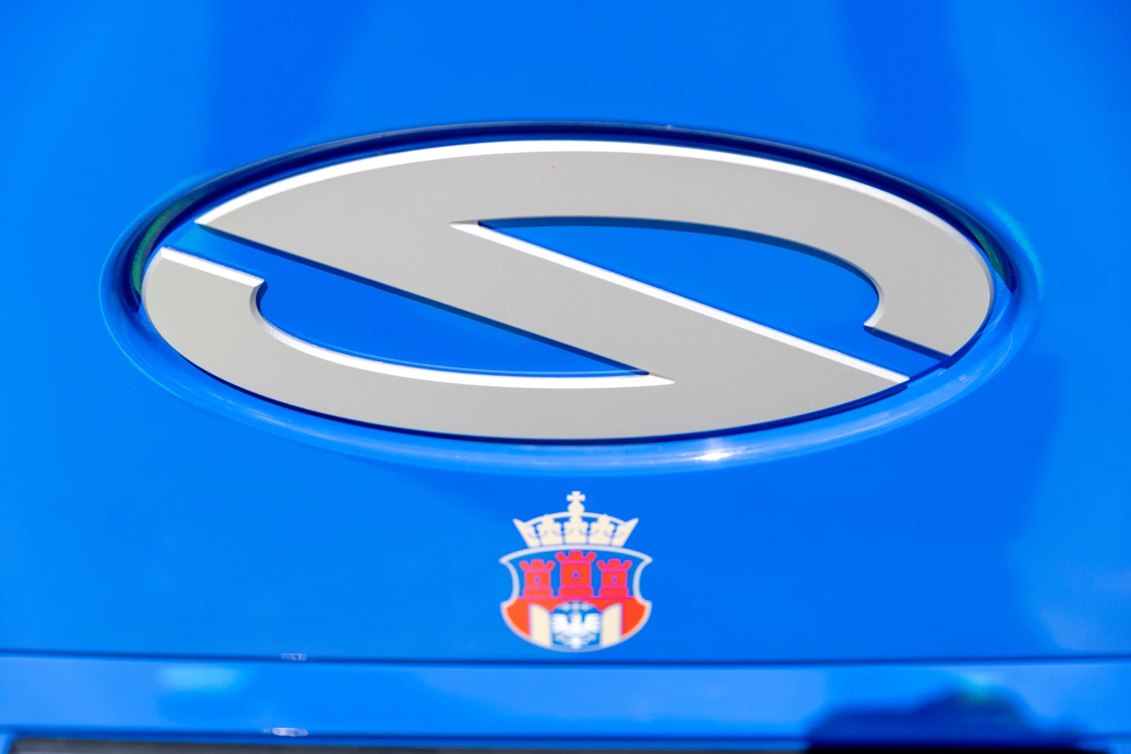 Logo marki samochodowej na niebieskim tle.  Autor: Bogusław Świerzowski