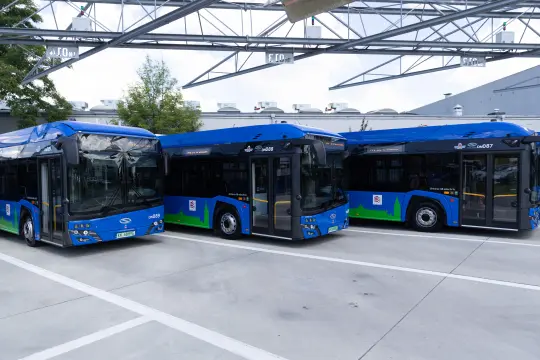 Trzy niebieskie autobusy elektryczne na parkingu.