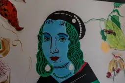 Portret kobiety z niebieską skórą i zielonymi włosami, ozdobiony biżuterią.