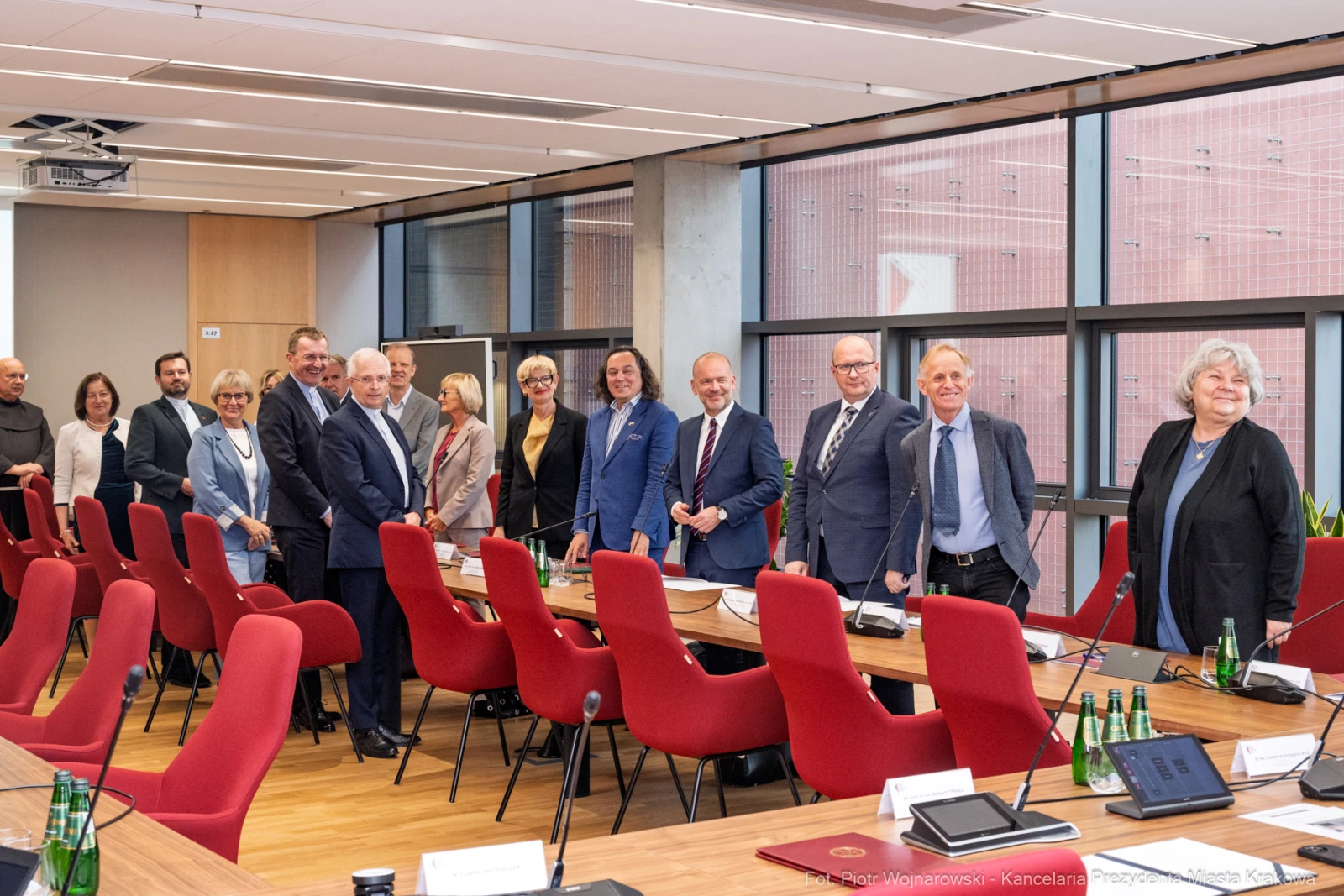 Grupa osób w formalnych strojach stoi przy stole w sali konferencyjnej.  Autor: Piotr Wojnarowski