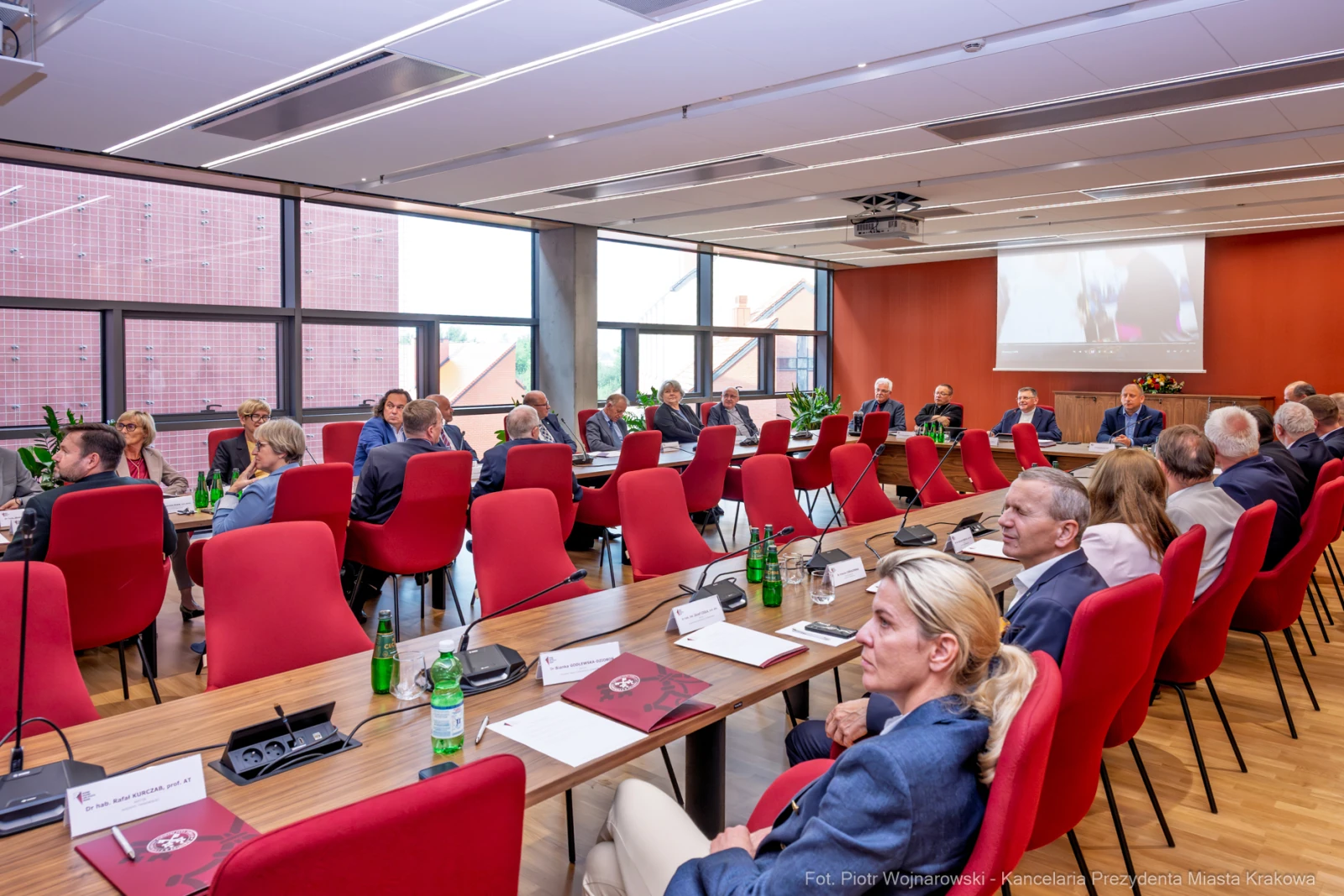 Spotkanie w sali konferencyjnej z uczestnikami przy stole i prezentacją na ekranie.  Autor: Piotr Wojnarowski