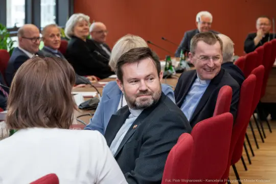 Spotkanie grupy ludzi w sali konferencyjnej, dyskusja i wymiana zdań.