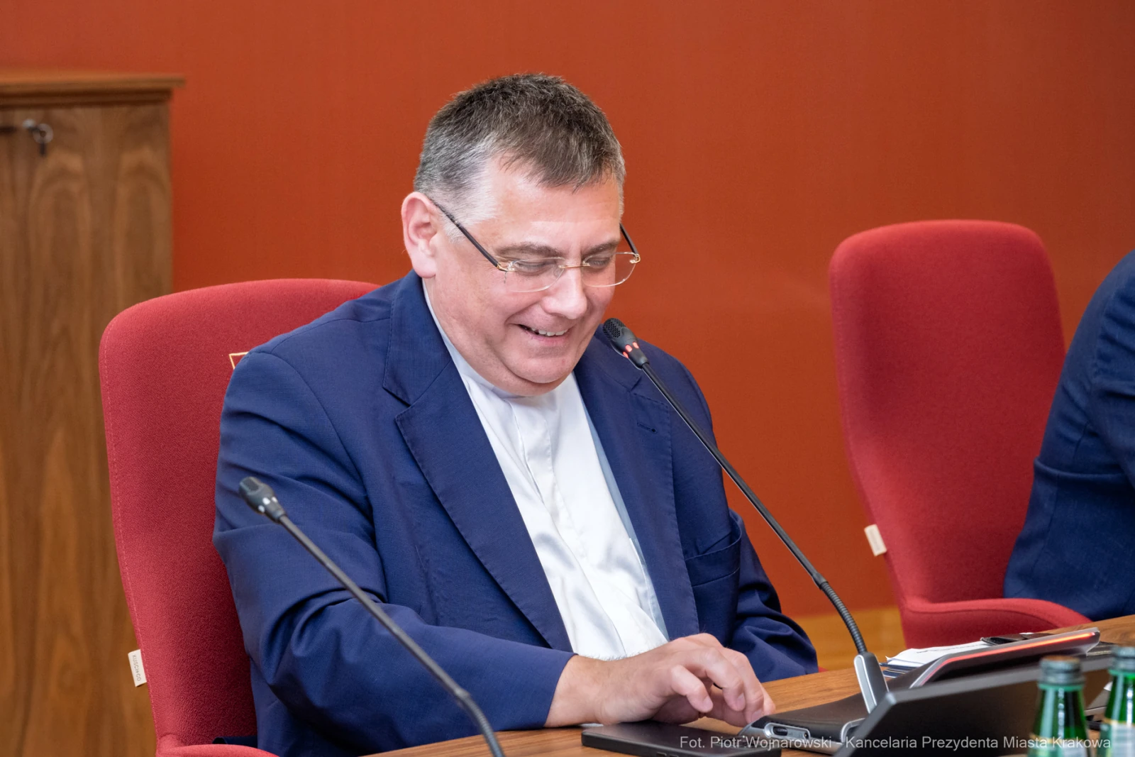Mężczyzna w okularach uśmiecha się, siedząc przy stole z laptopem.  Autor: Piotr Wojnarowski