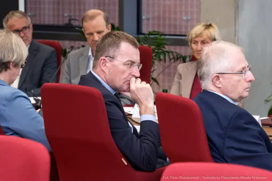 Grupa osób w trakcie dyskusji w sali konferencyjnej.