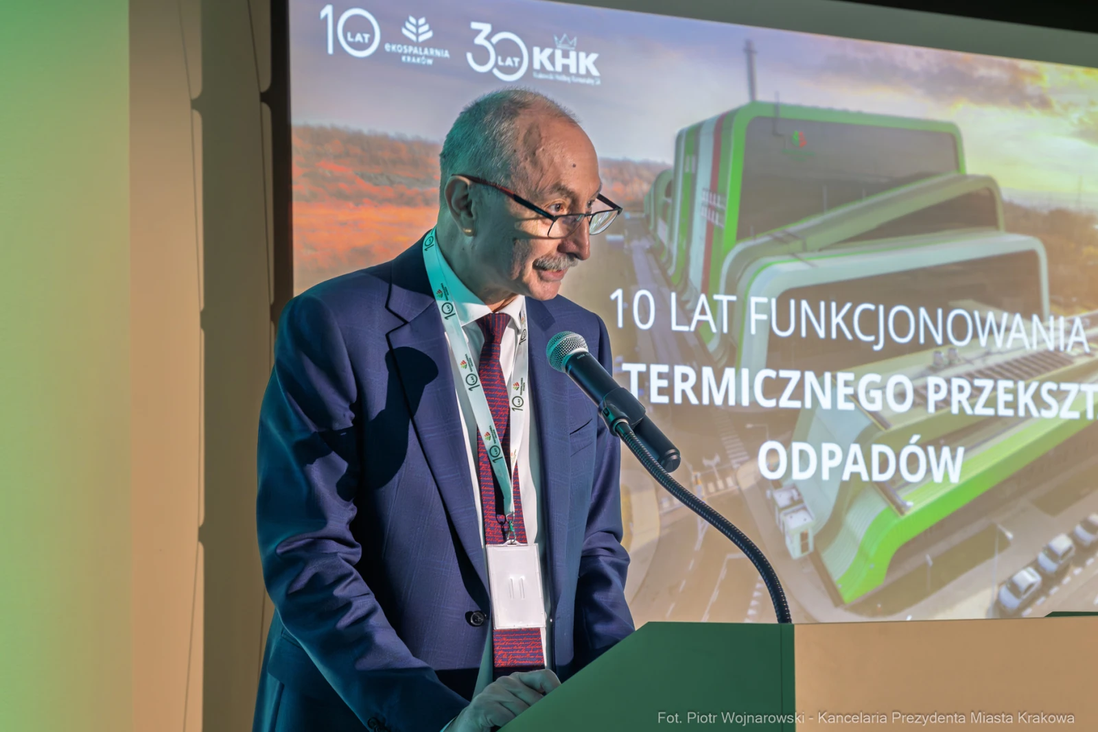 Mężczyzna przemawia na tle prezentacji dotyczącej 10-lecia funkcjonowania termicznego przekształcania odpadów.  Autor: Piotr Wojnarowski