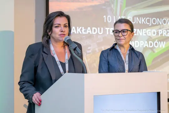 Dwie kobiety przemawiają na konferencji, prezentując osiągnięcia związane z zarządzaniem odpadami.