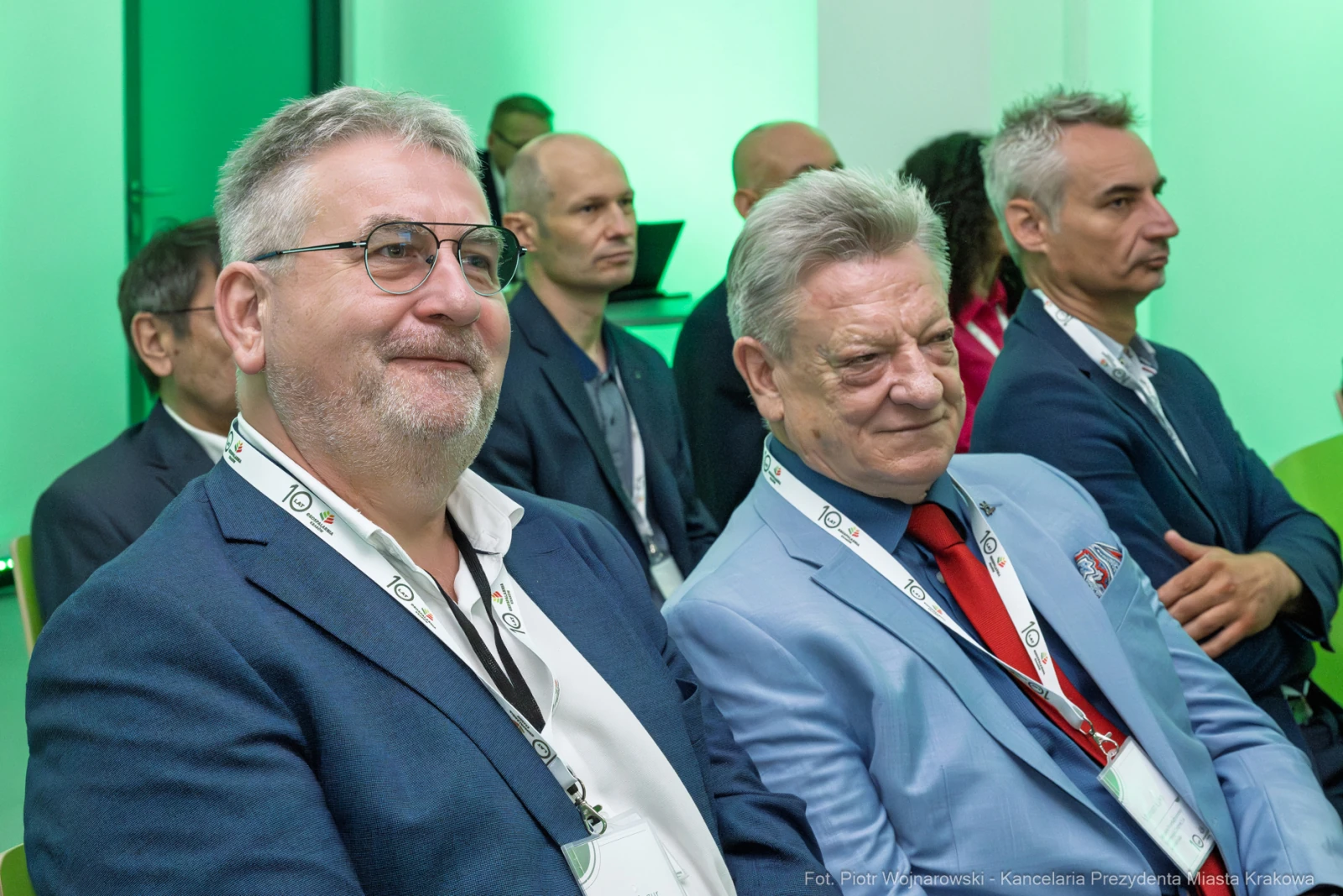 Dwaj mężczyźni w garniturach siedzący na konferencji, w tle inni uczestnicy.  Autor: Piotr Wojnarowski