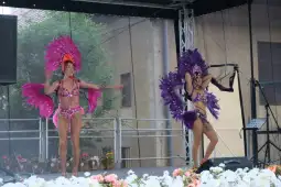 Tancerki w kolorowych kostiumach z piórami, występujące na scenie.